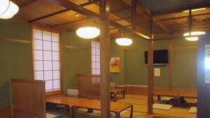 Una habitación tradicional japonesa con suelo de esteras de tatami, muebles de madera y puertas correderas shoji.