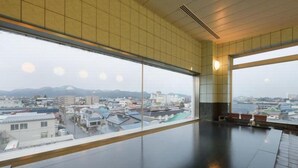 Una habitación amplia con ventanas grandes que ofrecen vistas a la ciudad.