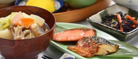 A variety of dishes including a bowl of soup, a plate of rice, and a dish with fish and vegetables.