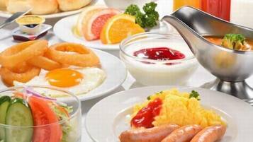 En morgenmadsopsætning med forskellige retter, herunder æg, pølser og en salat.