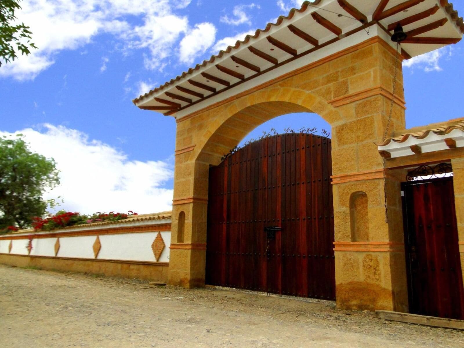 A stone archway leading to a gated entrance with a metal gate.