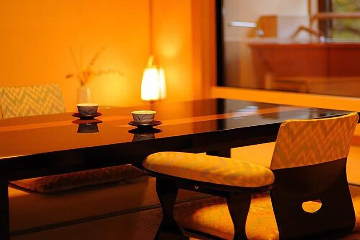 Ein traditioneller japanischer Raum mit Tatami-Böden, einem niedrigen Tisch und Kissen.