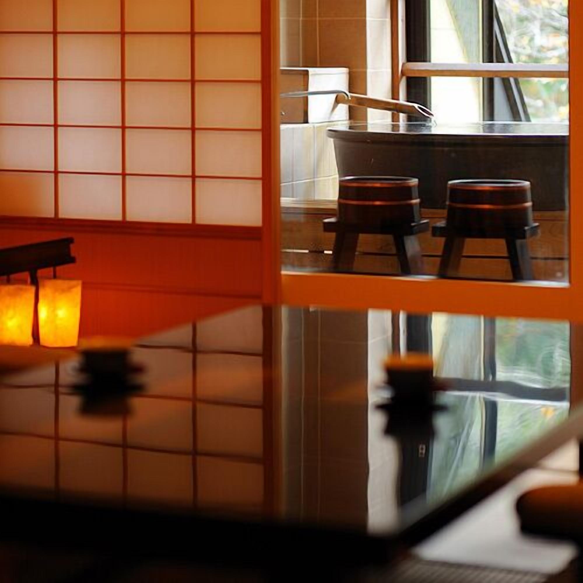A traditional Japanese room with tatami flooring, a low table, and a window with a view of the outdoors.