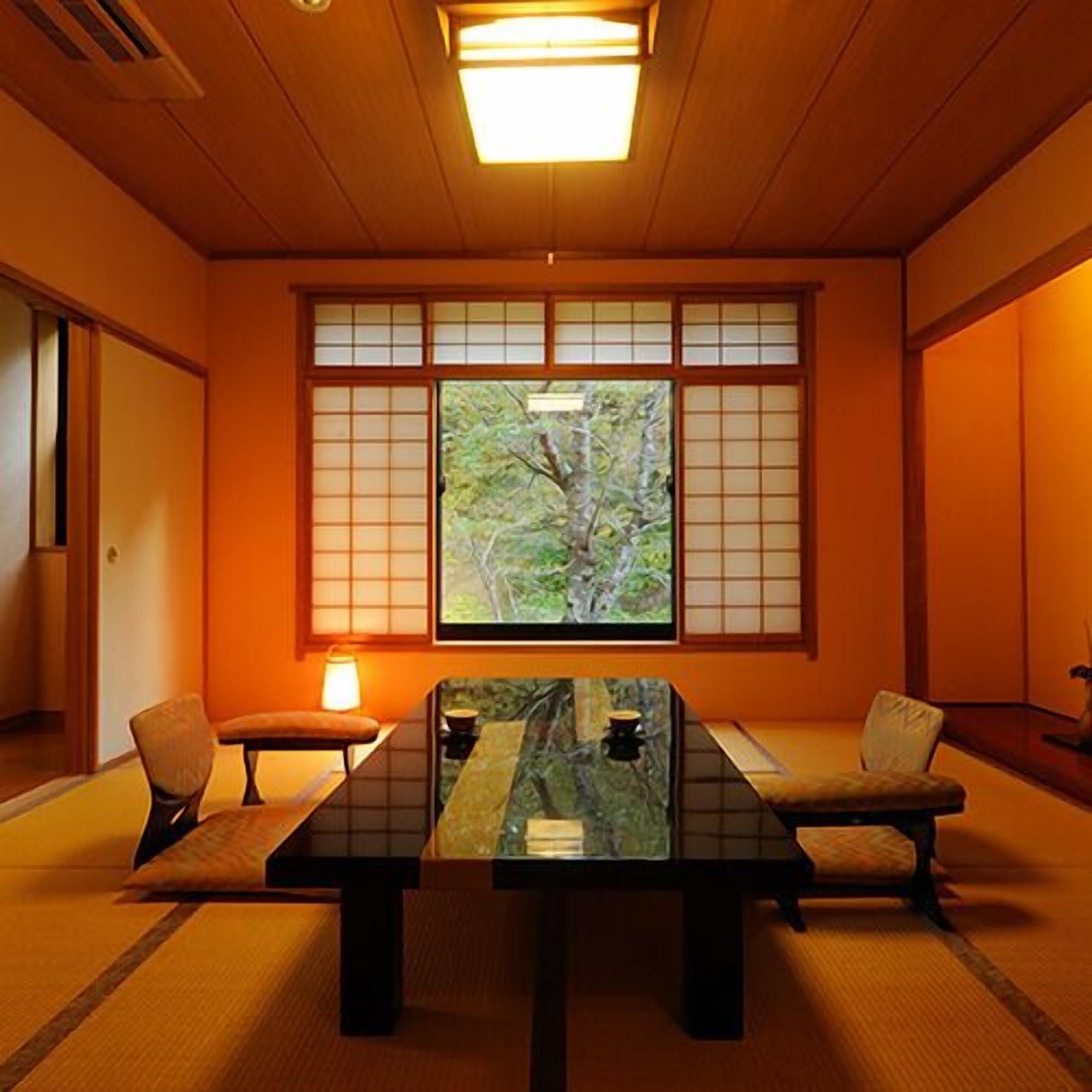 A traditional Japanese room with tatami flooring, a low table, and sliding doors.