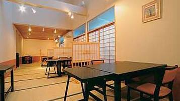 A traditional Japanese room with tatami flooring, low tables, and sliding doors.