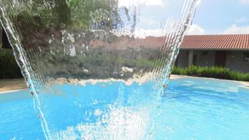 Una piscina al aire libre, sillones reclinables de piscina