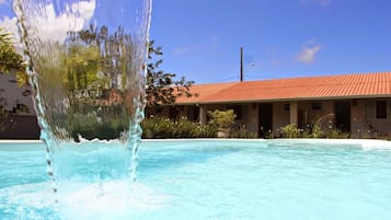 Una piscina al aire libre, sillones reclinables de piscina