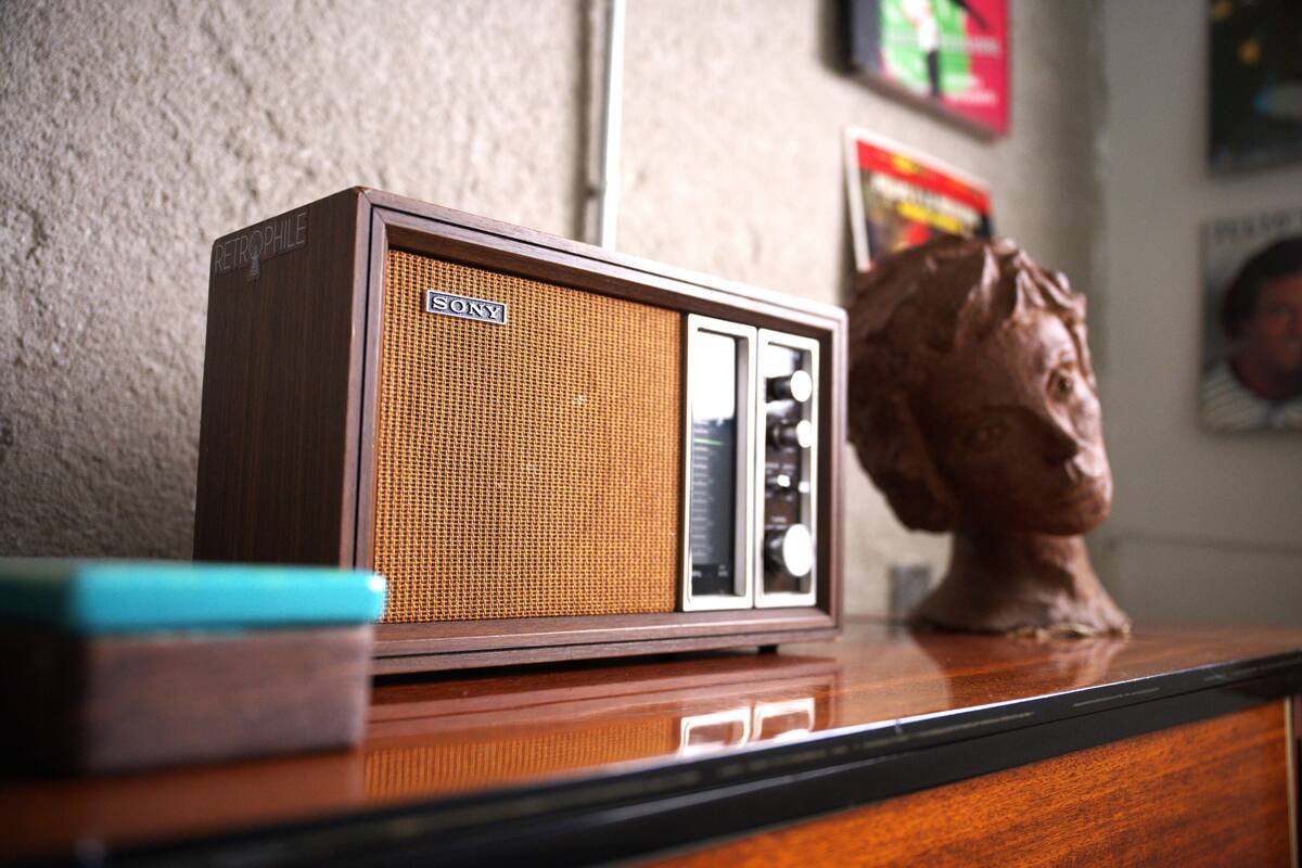 Ein umgebauter Sony-Fernseher auf einer Holzoberfläche, im Hintergrund eine Skulptur und ein gerahmtes Bild.