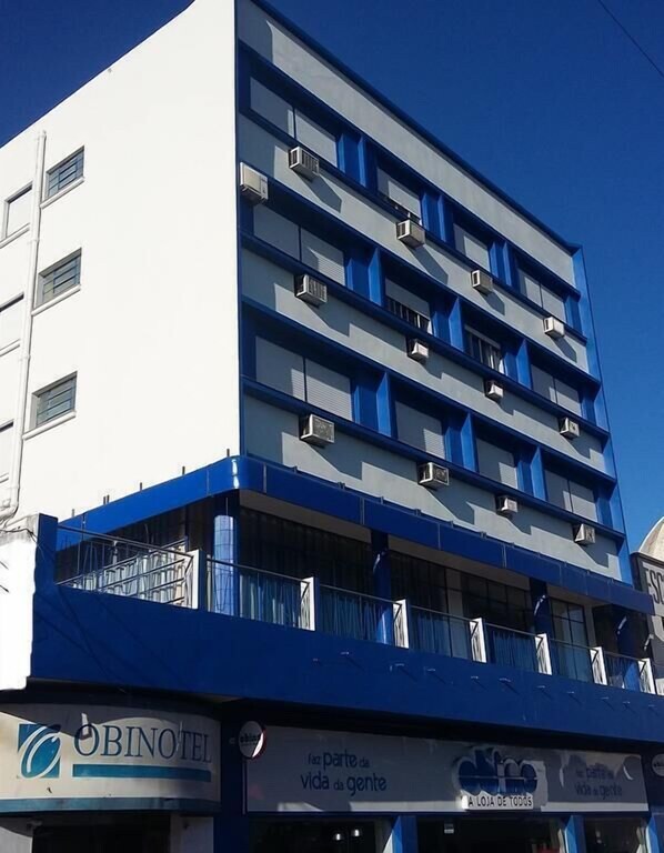 Ein mehrstöckiges Gebäude mit blau-weißer Fassade, ausgestattet mit Balkonen und Klimaanlagen.