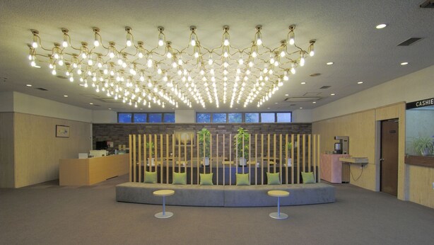 A spacious lobby with a central seating area, a reception desk, and a cash register. - Hamada NEW Castle Hotel (Hamada)