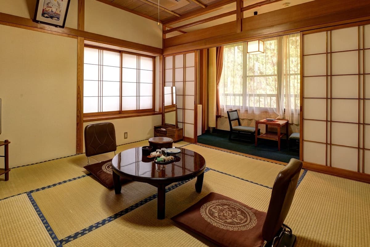 Egy hagyományos japán szoba, tatami szőnyeggel borított padlóval, tatami szőnyegből készült asztallal, televízióval és tolóajtókkal.