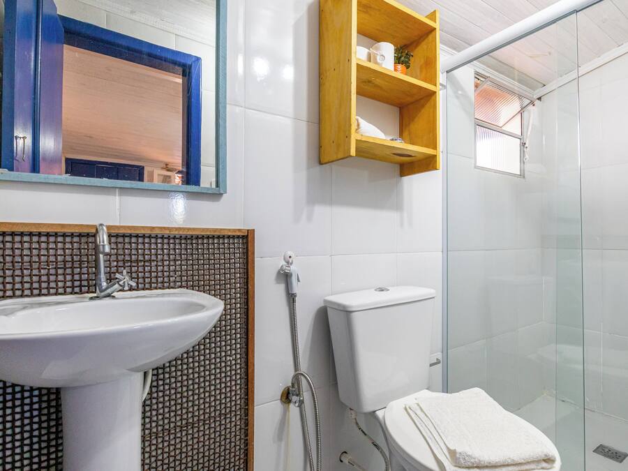 A bathroom with a sink, toilet, and glass shower enclosure.