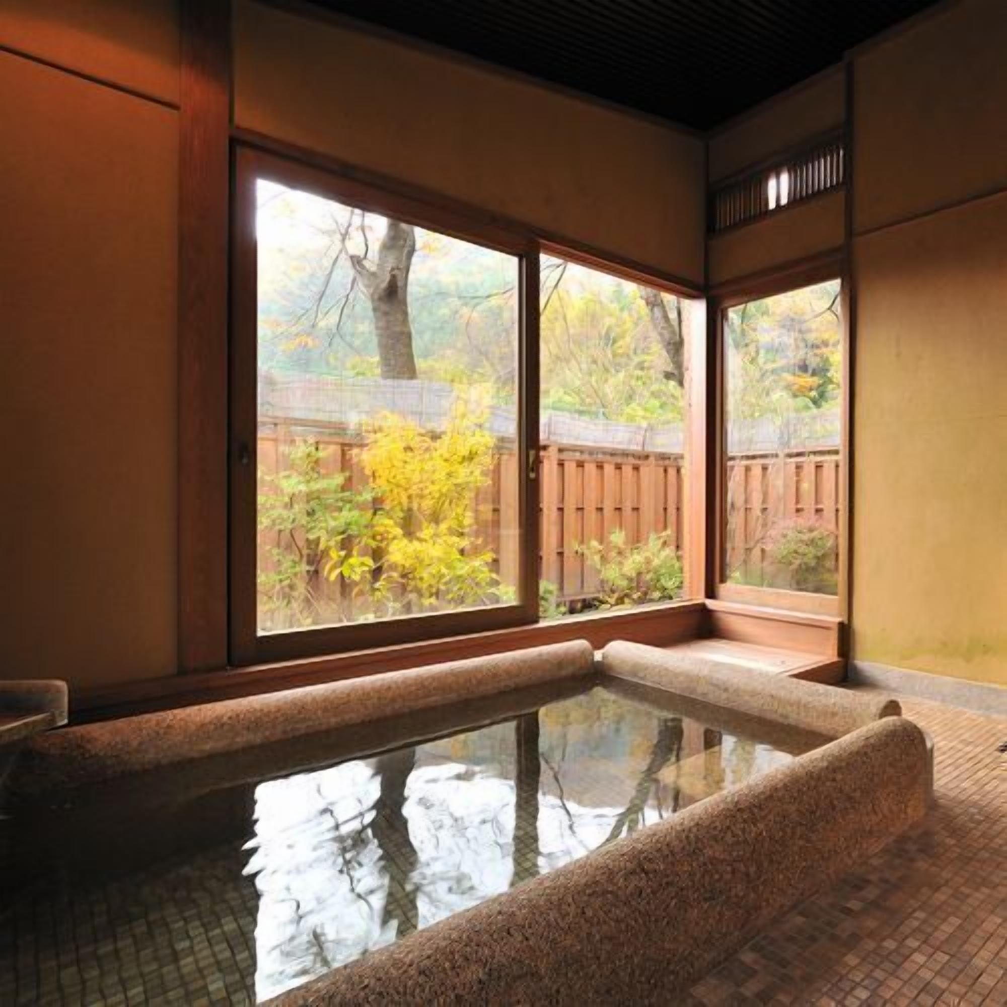 Un onsen japonés tradicional con un banco de madera y suelo de baldosas.
