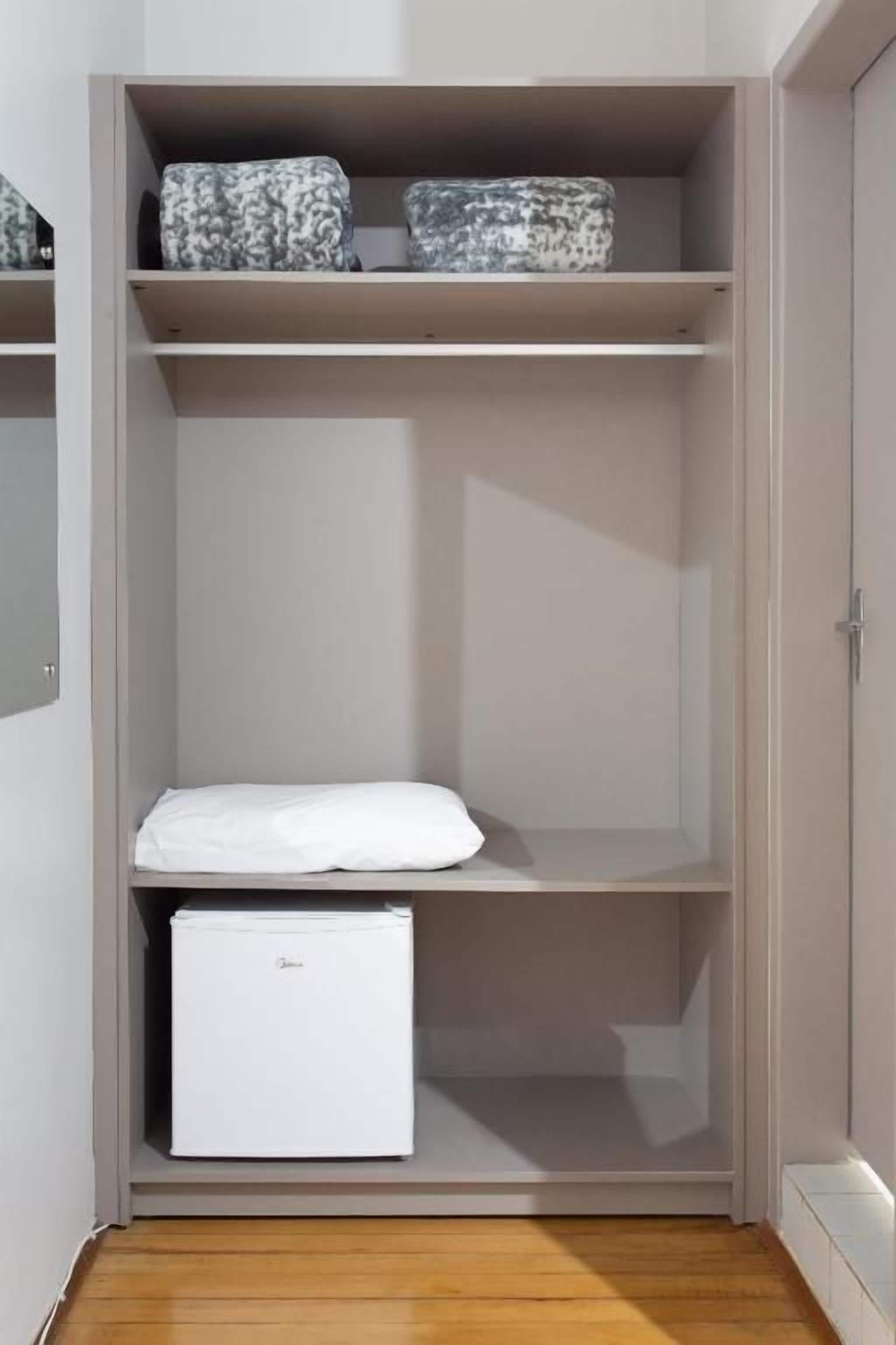 Un dressing avec des étagères, un meuble de rangement blanc et une porte.
