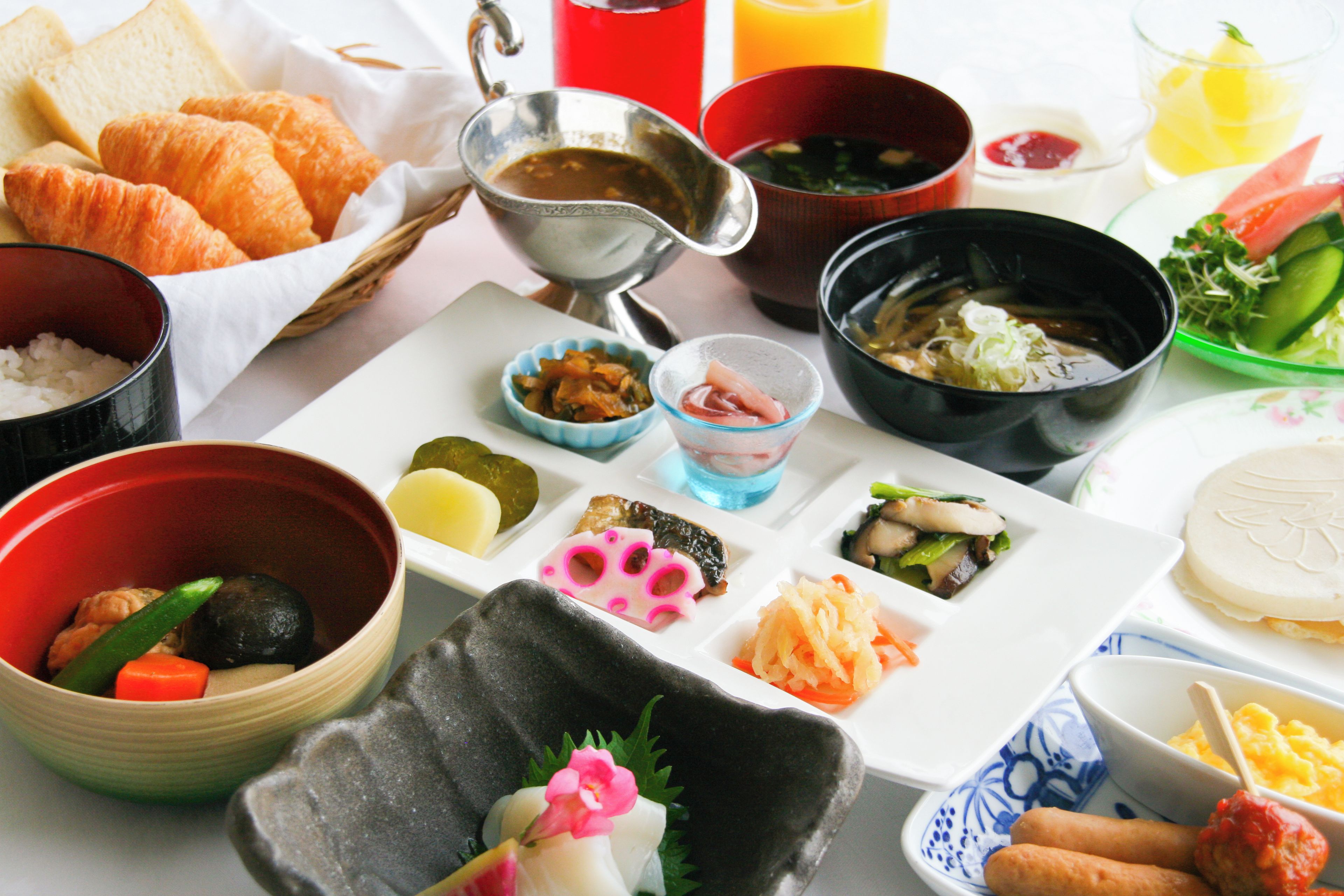 Una variedad de platos que incluyen sushi, sashimi y otras especialidades de la cocina japonesa, dispuestos sobre un plato blanco.