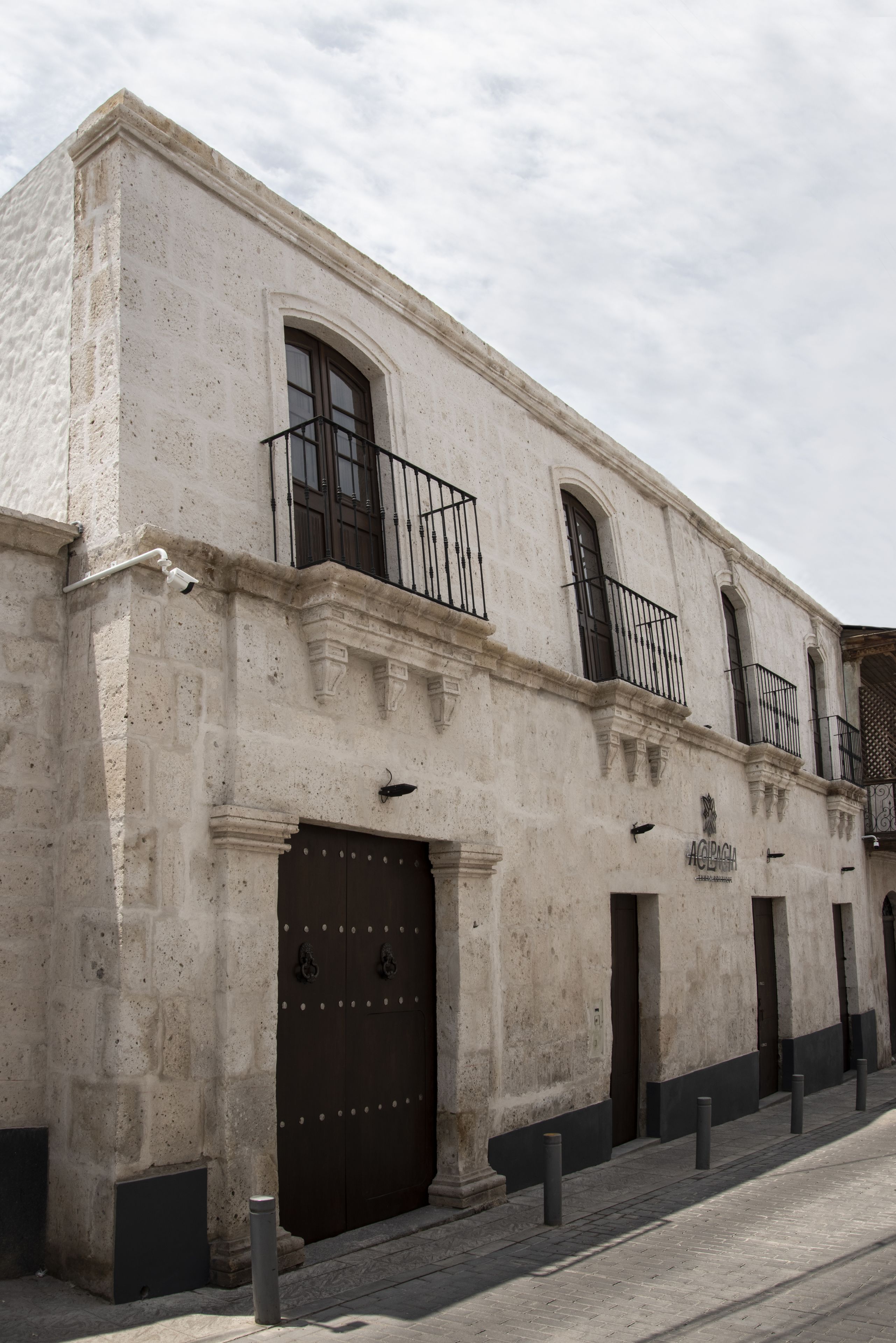 A historic building with a large central door, multiple windows, and a balcony.