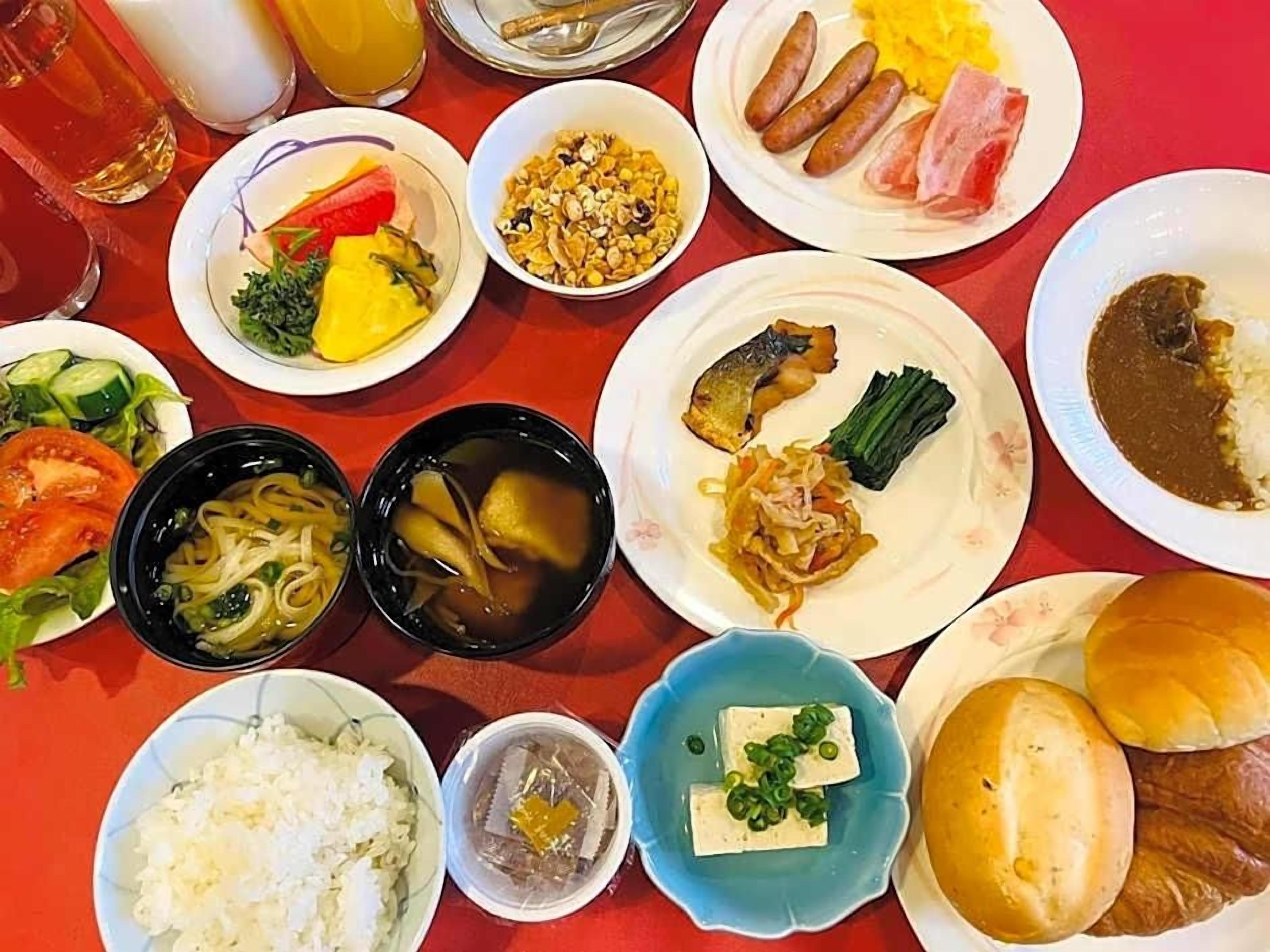 A table with various dishes including noodles, rice, and vegetables.
