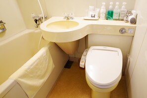 Et lille badeværelse med vask, toilet og håndklæderække.