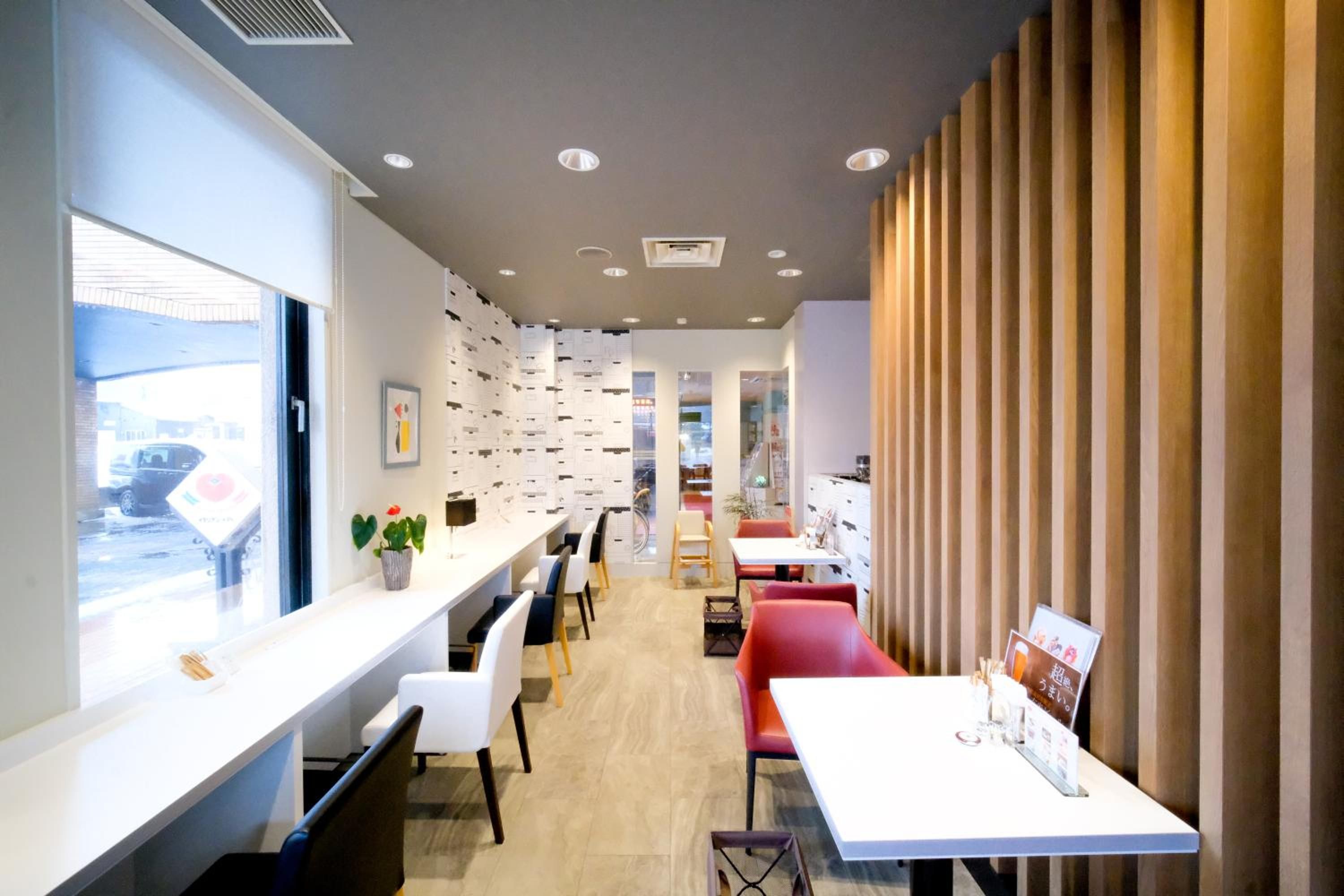 A modern interior with a long counter, seating area, and a view through a window.