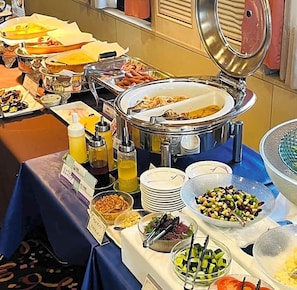 Een buffetopstelling met diverse gerechten en bijbehorende sauzen.