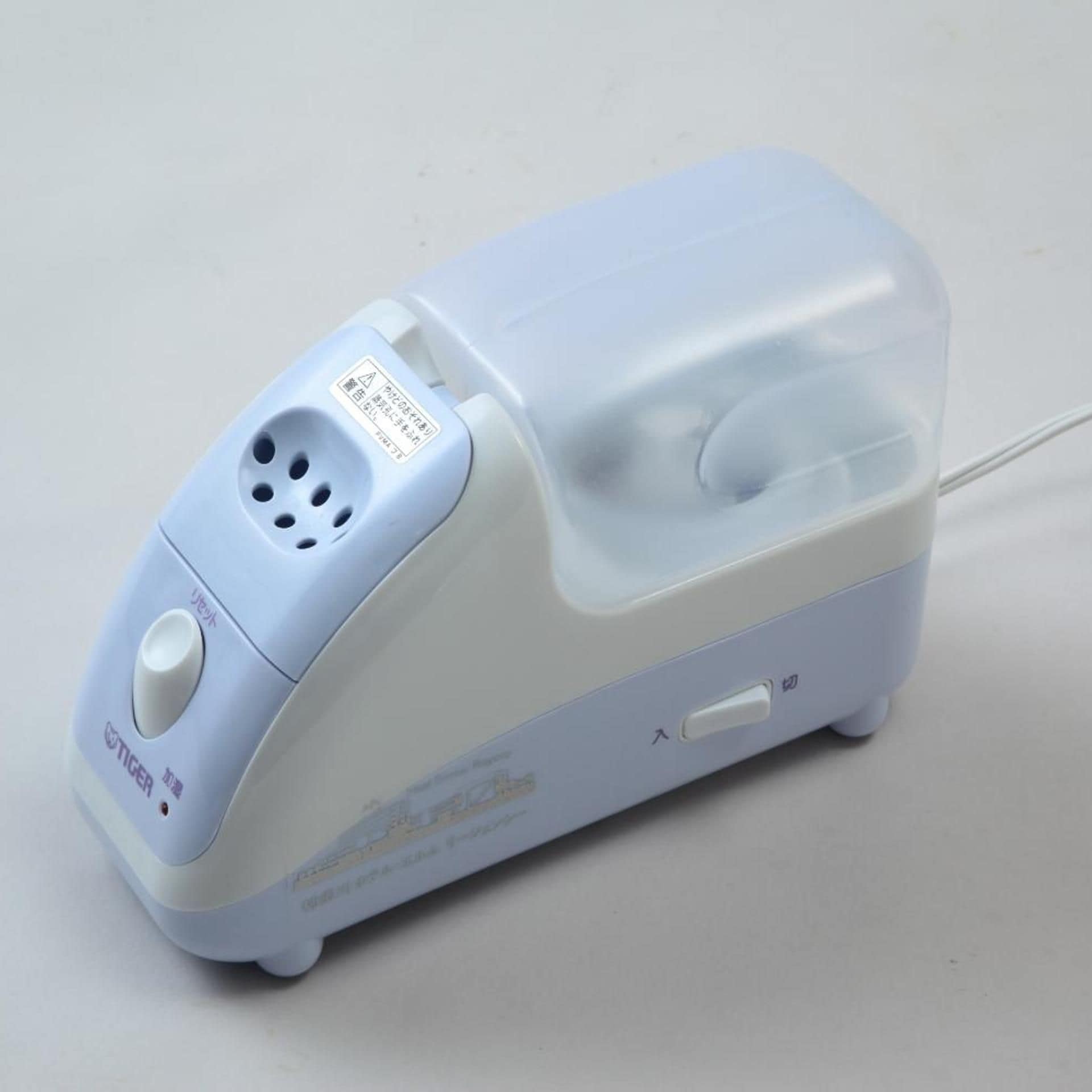 A portable device with a plug, a power button, and a USB port.