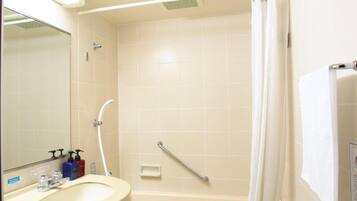 Een badkamer met een bad, een douche, een wastafel en een spiegel.