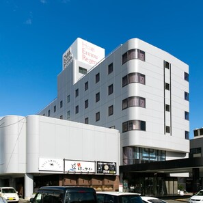 A modern hotel building with a prominent sign for 'Hotel Ernou Regina' on the top. - Hotel Elm Regency (Shimizu)
