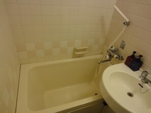 A bathroom with a bathtub, a sink, and a toilet. - Hotel Elm Regency (Shimizu)