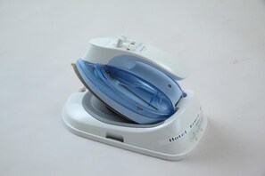 Un hierro de viaje blanco y azul con panel de control y cable de alimentación.