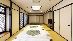 A traditional Japanese-style room with tatami flooring, a low table, and sliding doors. - Hotel Ermou Regency (Shimizu)