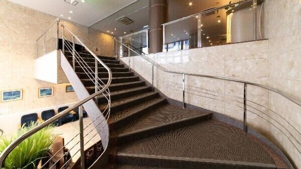 A modern staircase with metal railings, leading to a lower level. - Hotel Ermou Regency (Shimizu)