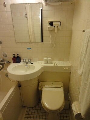 A small bathroom with a sink, toilet, and a mirror above the sink.