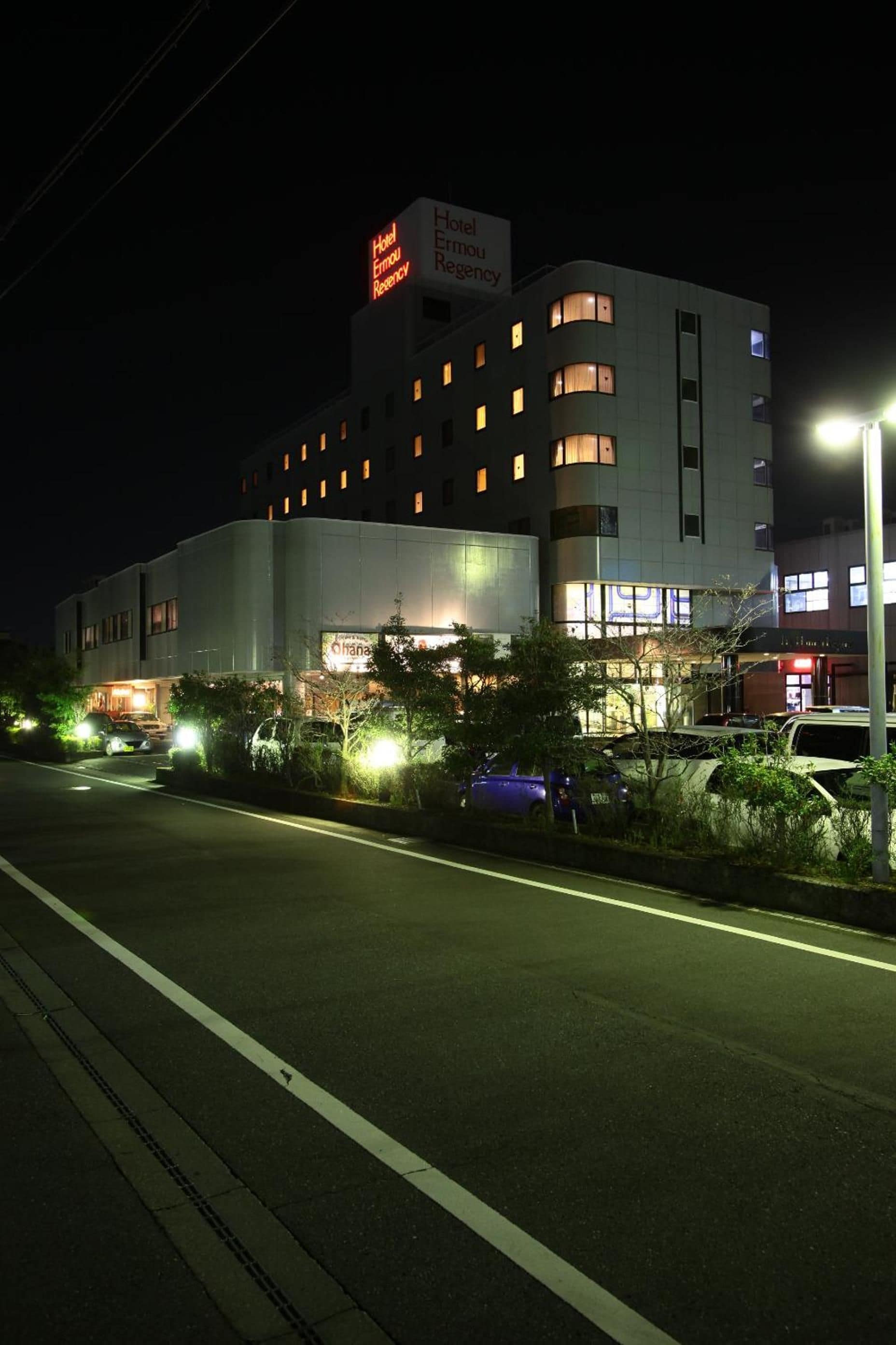 A multi-story hotel with illuminated signage and a parking area.