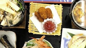 A variety of dishes including seafood, vegetables, and a bowl of soup, arranged on a table. - Fureaihouse Sizu NO Sato Sadogashima (Sado)
