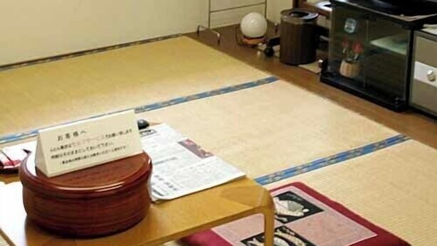 A room with tatami flooring, a television, a heater, and a small table with papers. - Fureaihouse Sizu NO Sato Sadogashima (Sado)