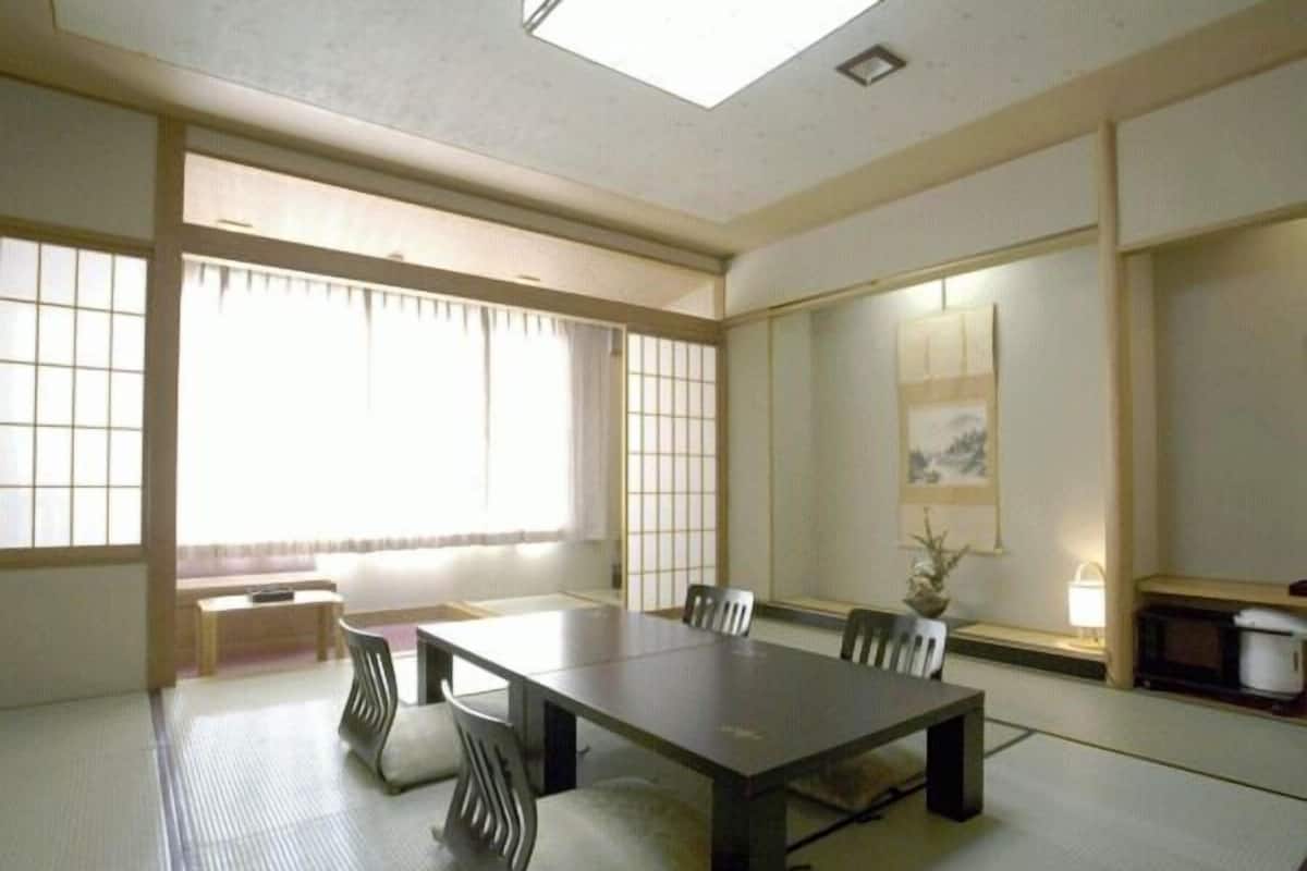 A traditional Japanese-style meeting room with tatami flooring, a low table, and shoji screens.