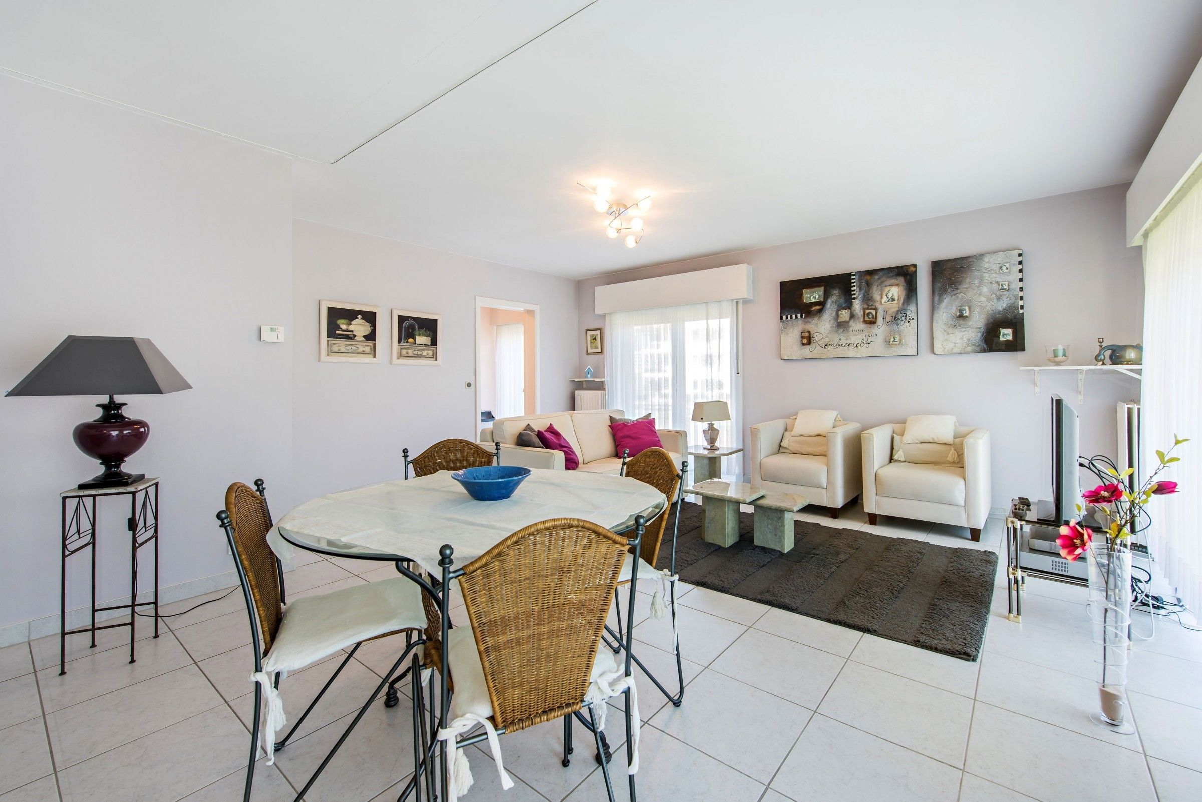A spacious living area with a dining table, chairs, sofas, and a coffee table.