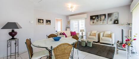 A spacious living area with a dining table, chairs, sofas, and a coffee table.