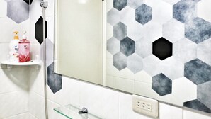 A bathroom with a shower, a glass shelf with toiletries, and a hexagonal tile backsplash. - Good-Days Lovely Suite BRT Calligraphy Greenway (West Dist.)