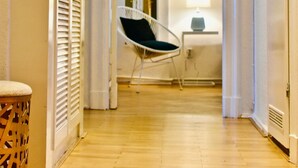 A hallway with a chair, a lamp, and a door leading to another room. - Aparthotel Thüringer Hof (Berlin)