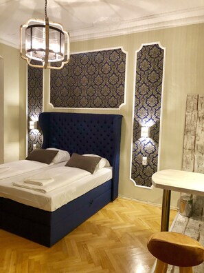 A bedroom with a large bed, a bedside table, and a chair.