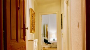 A hallway with wooden flooring, a white radiator, and a chair. - Aparthotel Thüringer Hof (Berlin)