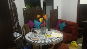 A cozy living area with a round table, a red sofa, and a decorative vase with flowers. - Lindo Apartamento en el Centro de Panama (Panama City)