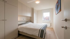 Un dormitorio con cama, armario empotrado y ventana con vistas.