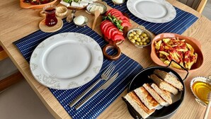 Un espace repas avec des tables rondes, des chaises et une variété de plats et de boissons.