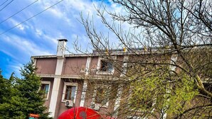 Deux motos sont garées dans une rue bordée d’immeubles, avec un parapluie rouge en arrière-plan.