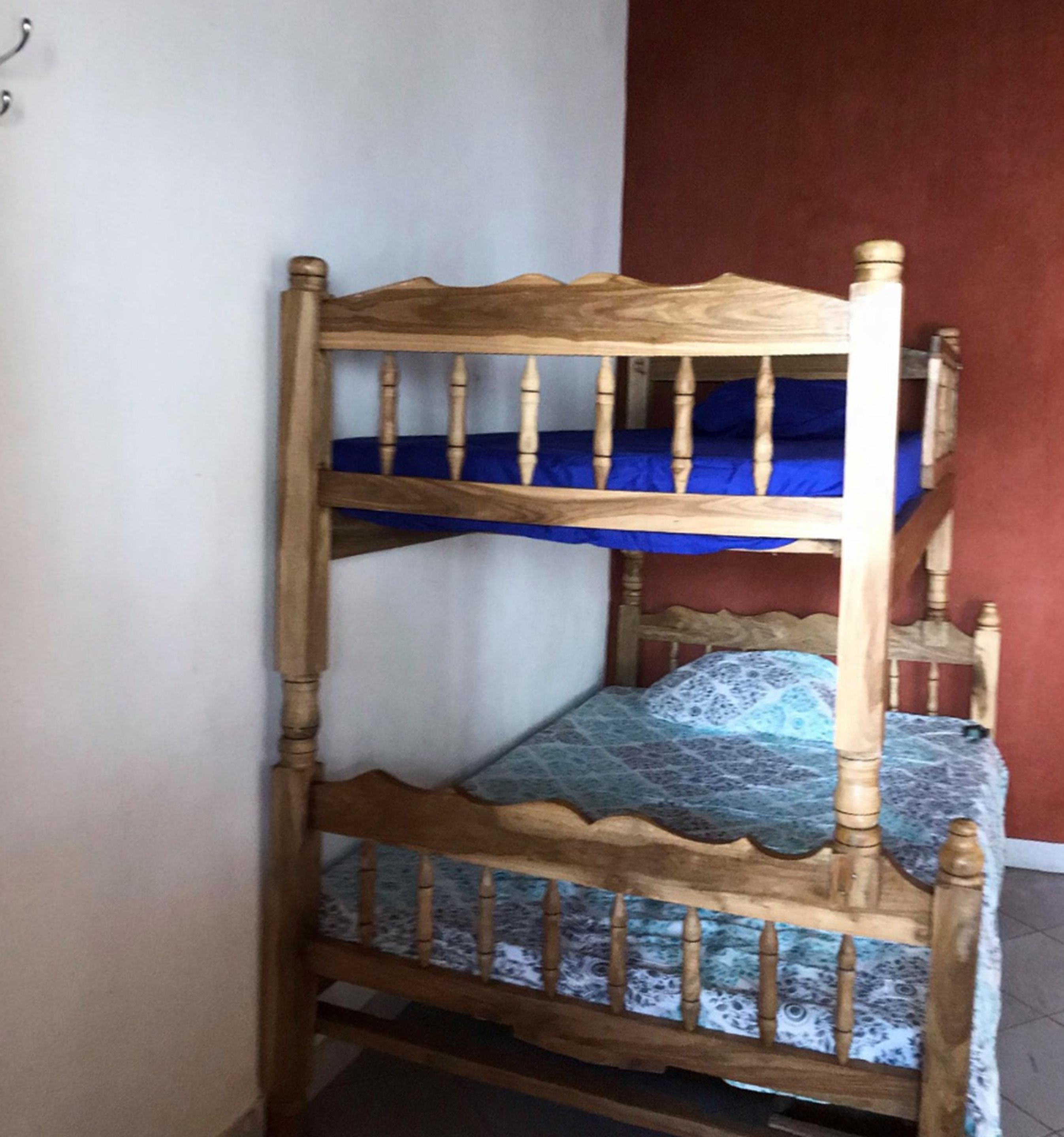 A bunk bed with a wooden frame and blue bedding.