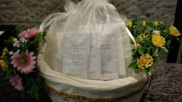 A wicker basket containing two bottles of cleansing oil and a bouquet of flowers.