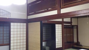 A traditional Japanese room with tatami flooring, sliding doors, and a low wooden bed. - Ryokan Hagurokan (Tsuruoka)