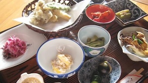 A traditional Japanese meal set on a tatami mat, including various dishes such as sashimi, tempura, and pickled vegetables. - Ryokan Hagurokan (Tsuruoka)